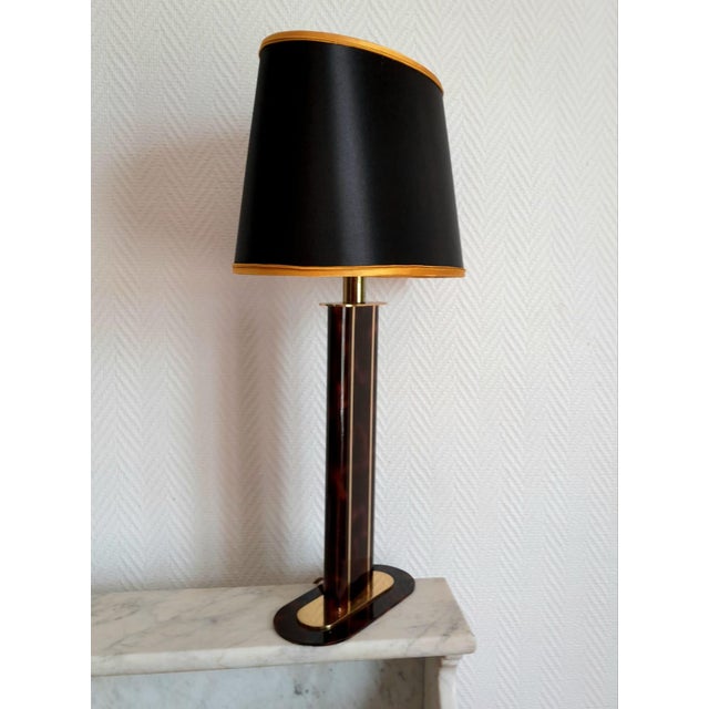 Vintage Hollywood Regency lamp, circa 1970/1980. The lamp base is finished in imitation tortoiseshell and brass. The...