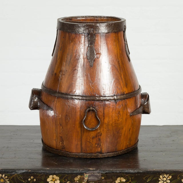An antique Chinese Qing Dynasty period handmade pear shaped wooden grain basket from the 19th century, with varnished...