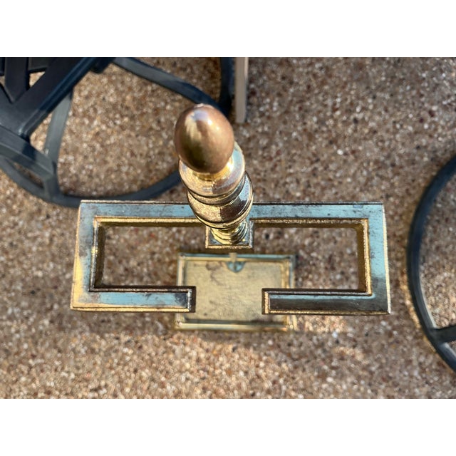 A handsome vintage brass fireplace companion set featuring a classic collection of hearth tools displayed on an elegant...