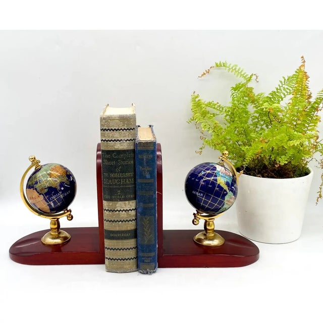 Incredible pair of globe bookends made with inlaid semi-precious stones, brass frames and wood bases. The globes feature...