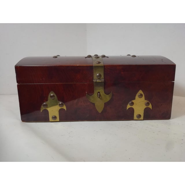 Burgundy lacquered wooden box with metal studs and a padlock. Shaped like an antique chest in a neo-medieval style. Wooden...