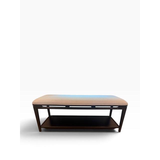 A handsome contemporary upholstered bench by Arhaus, featuring a streamlined dark-finished wood frame, neutral upholstered...