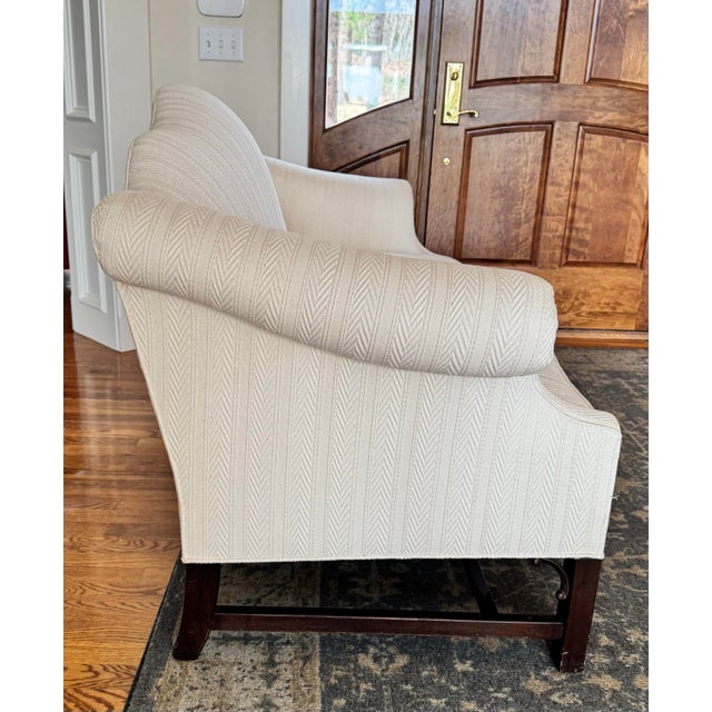 The sofa is designed in a traditional Chippendale or Queen Anne style, commonly associated with 18th-century English...