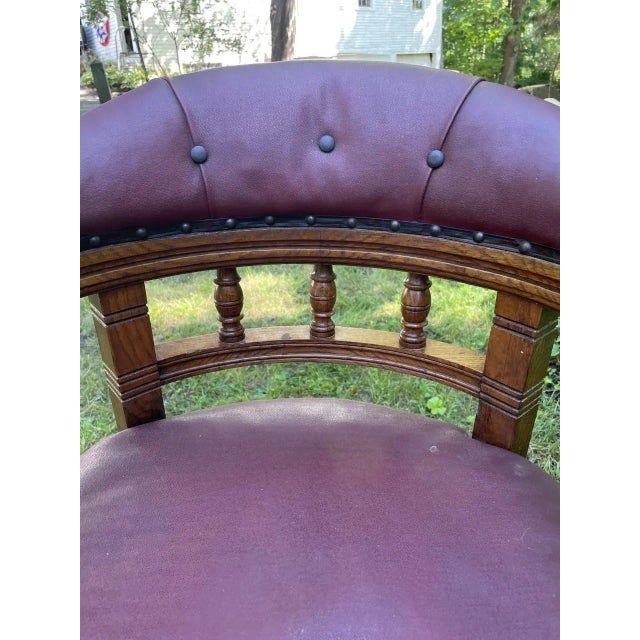 English Victorian (c1880) desk chair in oak with curved arm/back on turned legs in front with castors, saber legs in rear,...