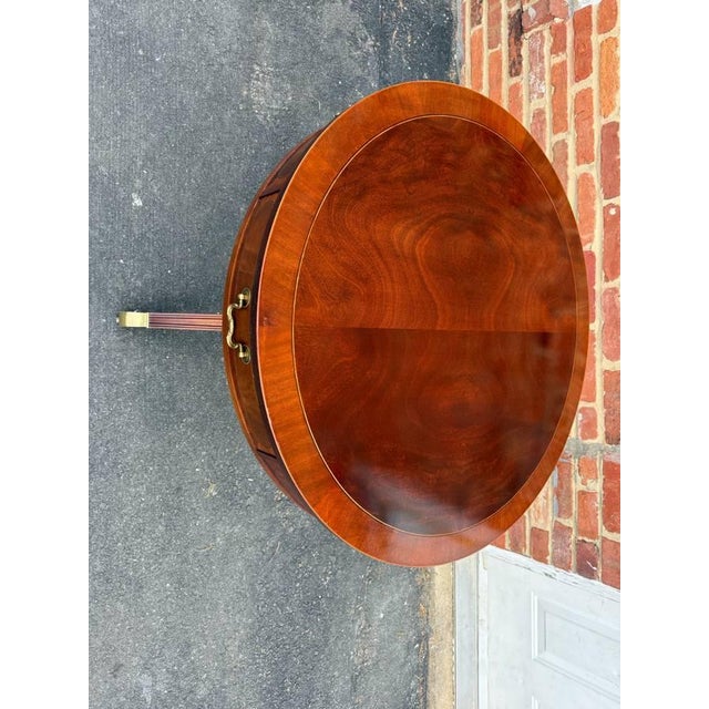 Baker Furniture Federal Style Inlaid Mahogany Two-Drawer Pedestal Base Drum Table Side Table It features brass hardware,...