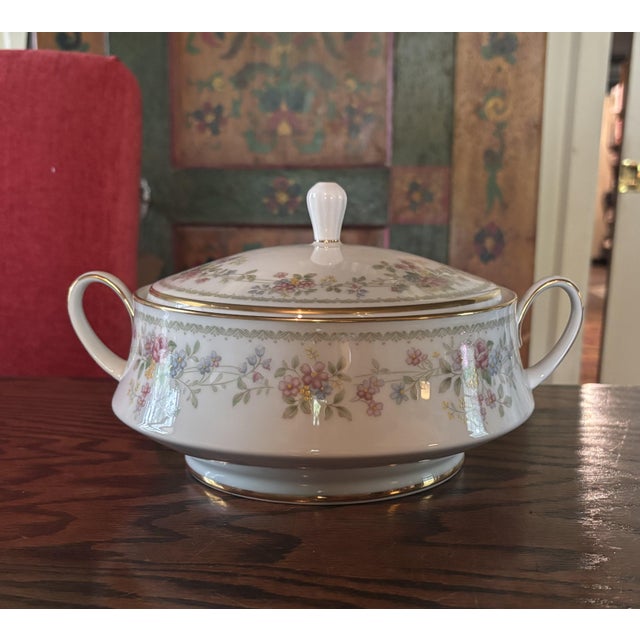 A classic full China set for 12 with delicate pink, blue, green, and yellow floral details. The gold trim adds an elevated...