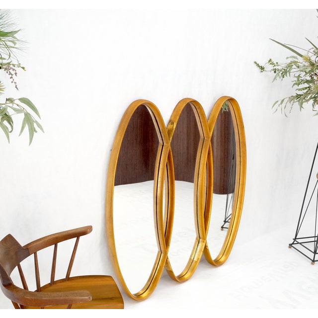 Mid-Century Modern tripple overlapping carved wood ovals gold gilt wall mirror. Sophisticated example of actual carved or...