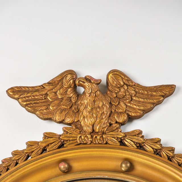 Fantastic large gilded wood convex glass eagle mirror. This bullseye mirror features the perched American eagle and...