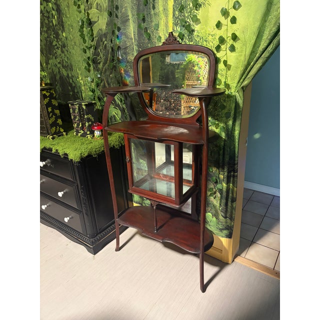 Early 20th century Art Nouveau Mahogany Etagere with mirror, shelves, & center curio cabinet. Both beautiful and...