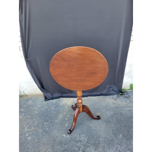 This 19th century American cherry candle stand table is a beautifully refurbished antique piece with a unique oval shape...