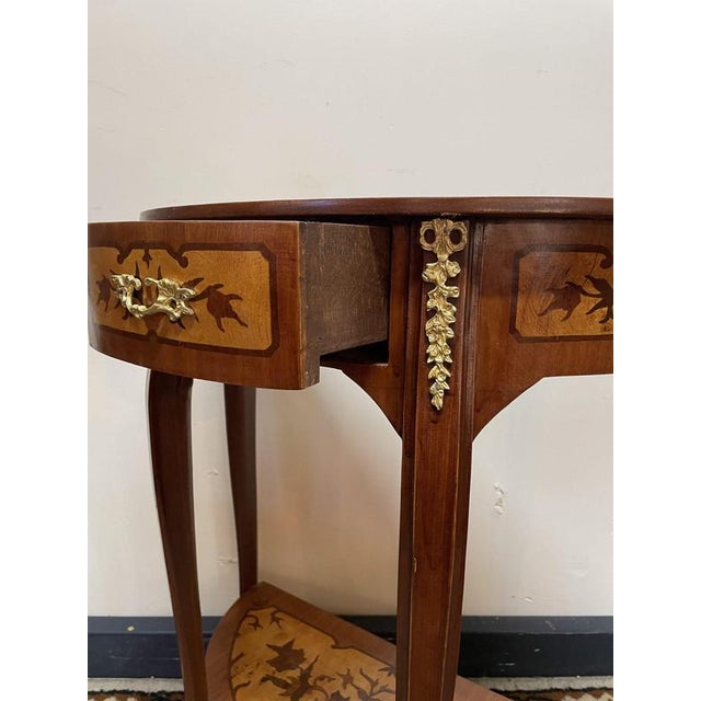 Beautiful antique-style demi-lune console table featuring fine parquetry inlay with floral and urn motifs and ornate brass...