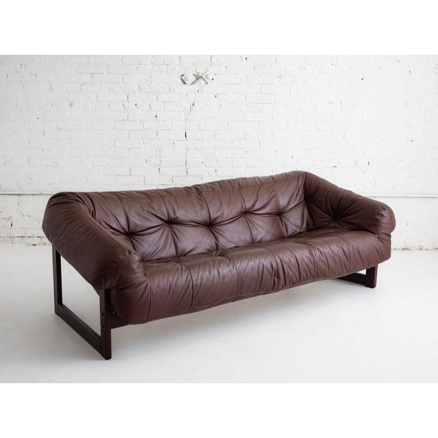 Modernist tufted sofa in brown aniline leather designed by Percival Lafer. Constructed with molded foam, rosewood, and...