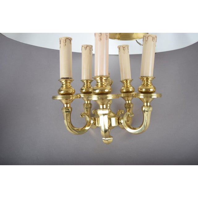 A charming and atmospheric bouillotte-style pendant chandelier, combining a warm polished brass six-light frame with a...