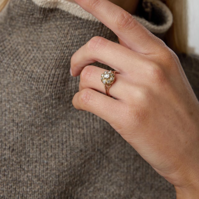 A romantic treasure from the turn of the century, this Victorian cluster ring showcases nine captivating old mine cut...