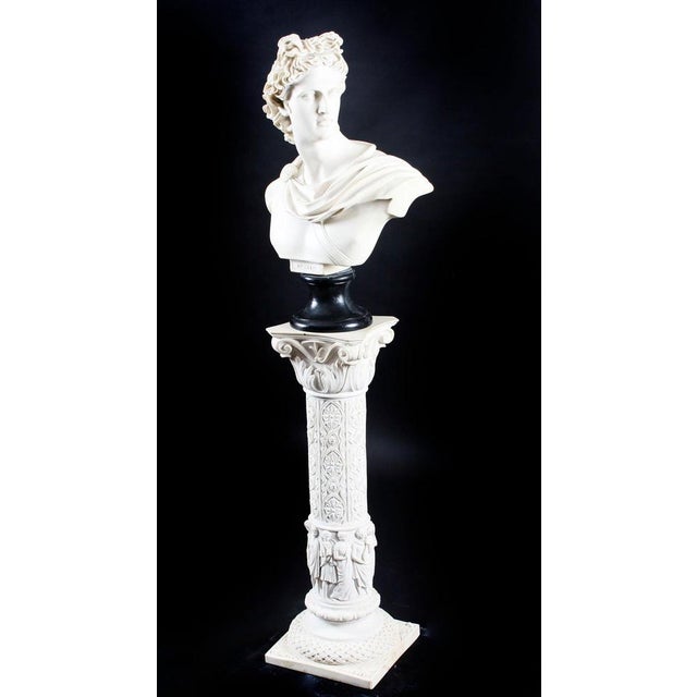 A beautifully sculpted marble bust of the famous Greek god Apollo, on it's original fabulous decorative pedestal, dating...