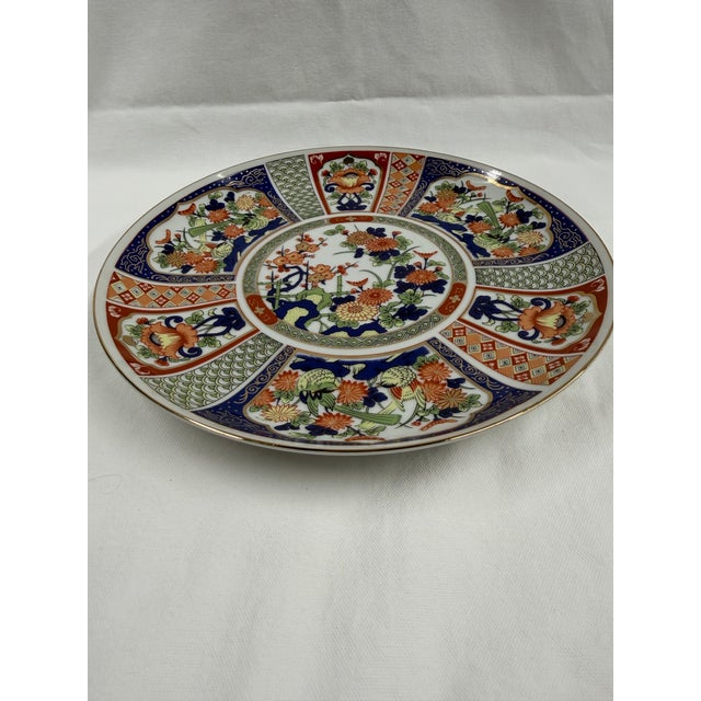 A vintage Japanese Imari porcelain plate featuring a traditional panel design in cobalt blue, red, and gold. Original...