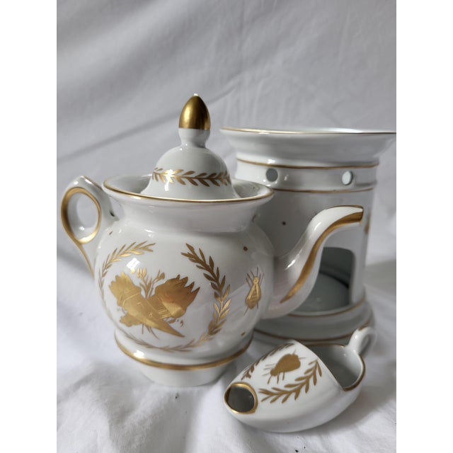 An exceptionally preserved 19th-century French hard-paste porcelain herbal tea teapot and warming nigh light pedestal...