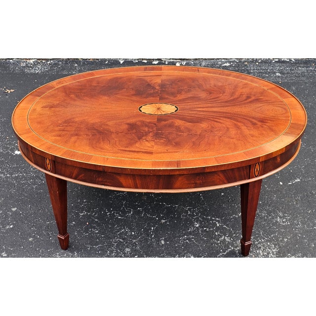 This coffee table features mahogany solids with a yew wood border and a swirl mahogany inset on the top. It also has...
