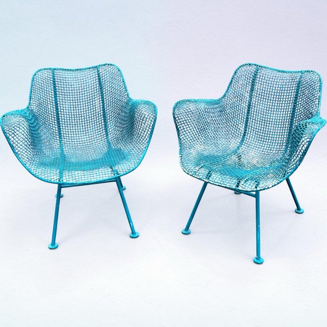 An original pair of wrought iron classic sculptura pattern lounge chairs by Woodard. Each measure 27” x 27” x 25” d. Old...