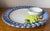 This wonderful Hand-painted faience chip & dip platter features 'Tromp L'oiel' cheese and grapes and a sauce or dip...