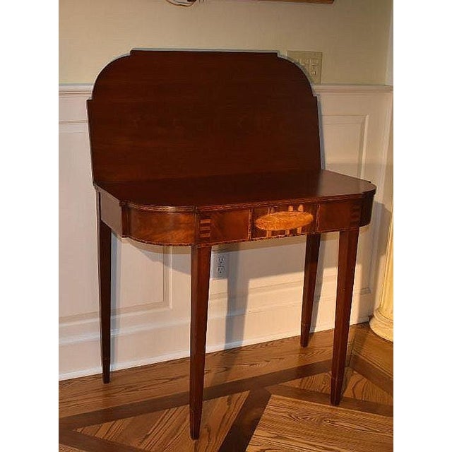 American inlaid mahogany Hepplewhite folding top games table circa 1785. A folding arcaded top rests above a conforming...