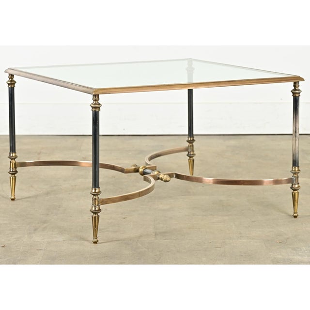 A vintage, mid-century French brass and glass coffee/cocktail table in the style of legendary firm Maison Jansen. In their...