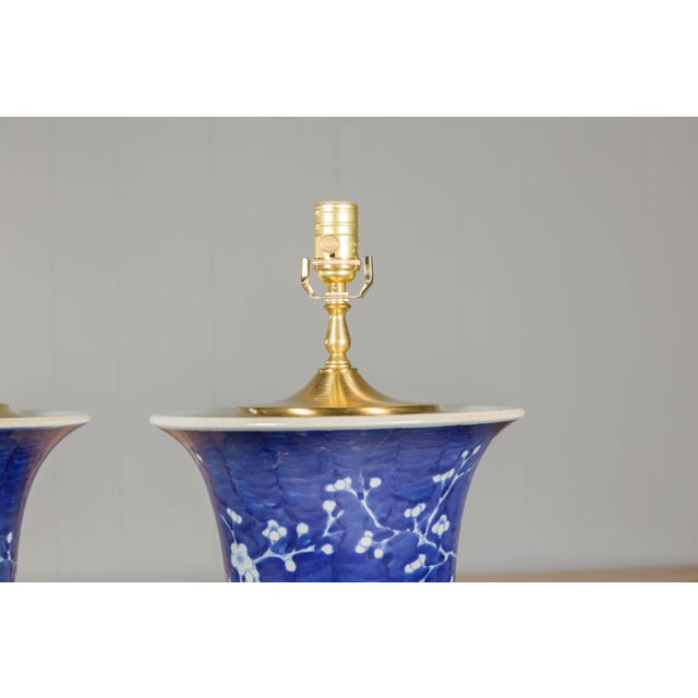 A pair of Midcentury Asian blue and white porcelain table lamps with floral décor on gilded bases, rewired for the USA....