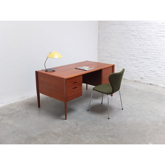 Beautiful desk in teak manufactured by Wilhelm Renz around 1960. It has three drawers on the left and shelves on the right...