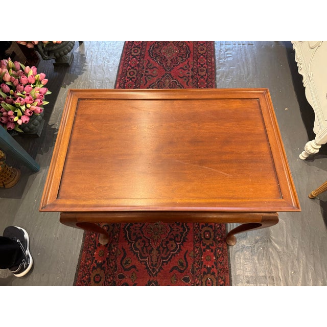 This is an Eldred Wheeler tea table. It is made of cherrywood. It has pullout shelves on each side. It has a queen Anne...