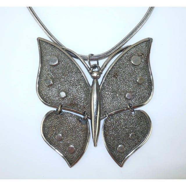 1970's large and in charge butterfly pendant added to a contemporary chain both in a silver metal. The pendant is...