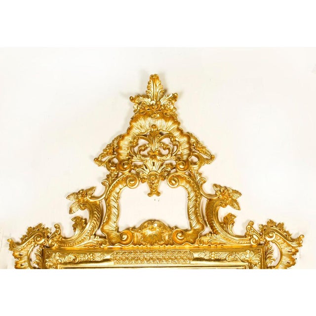This is a finely hand carved monumental Italian Rococo Revival giltwood mirror, dating from the late 20th century. It...