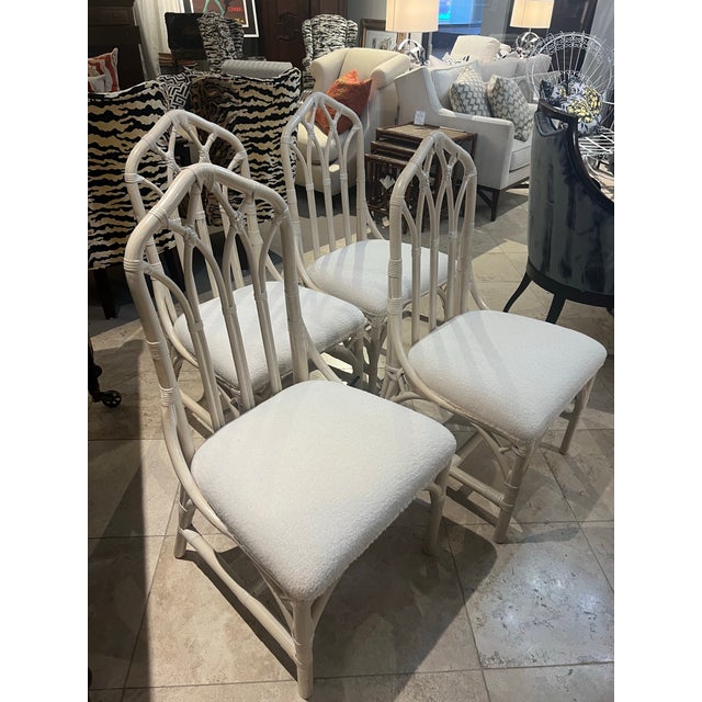 Set of four vintage cream bamboo dining chairs featuring striking cathedral-arch backs and a fresh coastal finish.