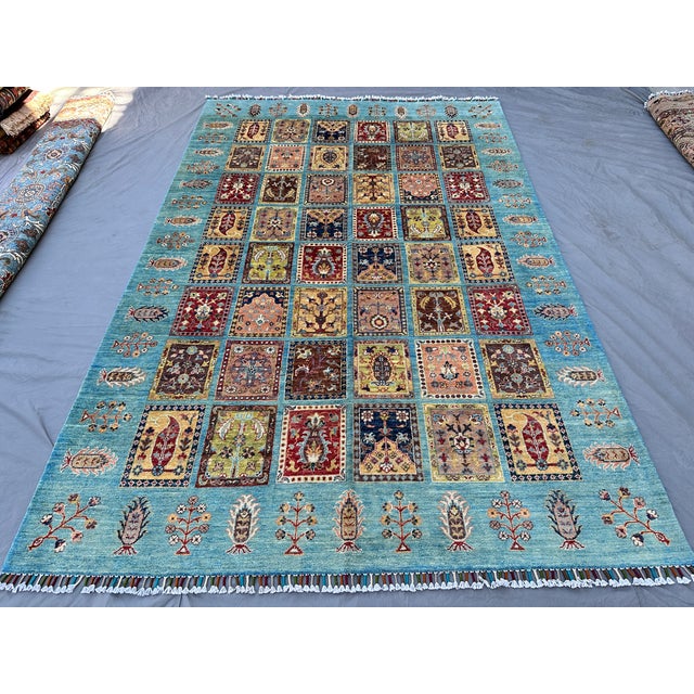 This captivating Bakhtiari rug showcases the iconic garden panel design: a grid of individual compartments, each holding...