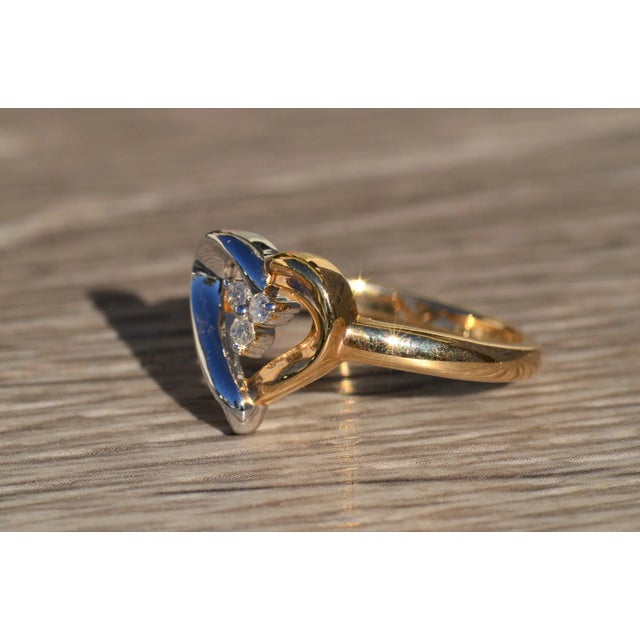 The Carina Two-Tone Gold Heart and Diamond Ring. This ring is crafted in 14 karat white and yellow gold. The open heart...