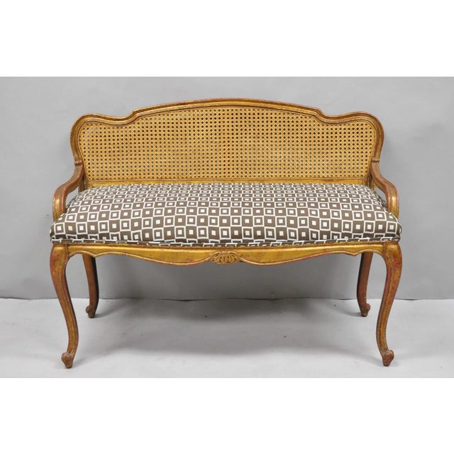 Vintage French Louis XV Style Distressed Gold Gilt Cane Back Vanity Bench Seat. Circa Mid 20th Century. Measurements:...