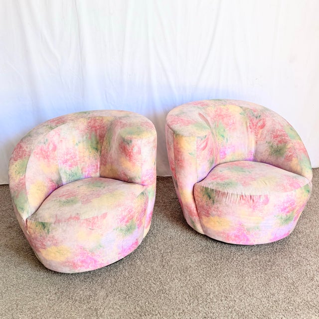 A striking pair of postmodern Directional swivel lounge chairs wrapped in a dreamy, painterly upholstery of soft pinks,...