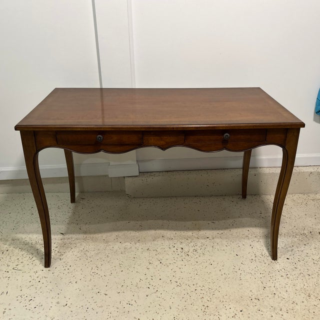 This Classic Drexel Heritage Writing Desk has two drawers with brass hardware. The cabriole legs provide a look of...