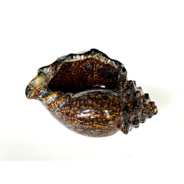 This vintage ceramic conch shell planter figurine is a dramatic piece of art pottery. Display the vintage ceramic seashell...