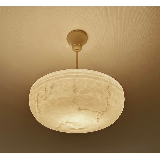 Art Deco pendant lamp from the 1930s, ivory marble glass shade with darker veins, translucent bakelite glass holder ,...