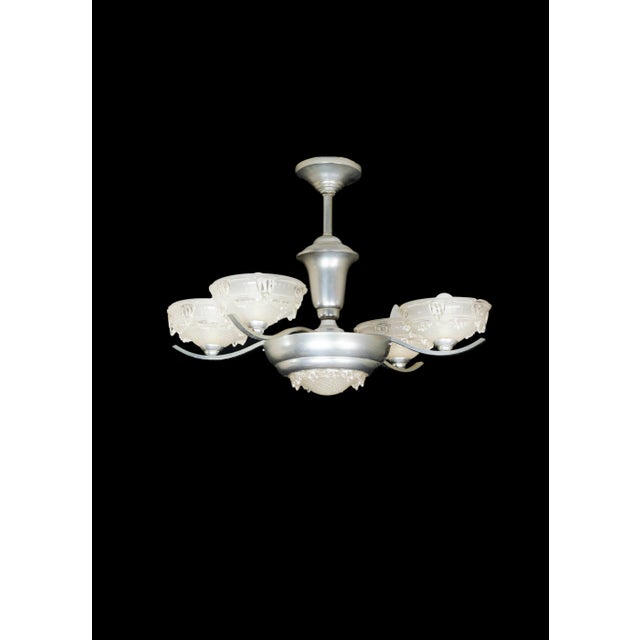 An art deco bistro chromed color four arms chandelier with frosted glass. the chandelier is currently wired for both...
