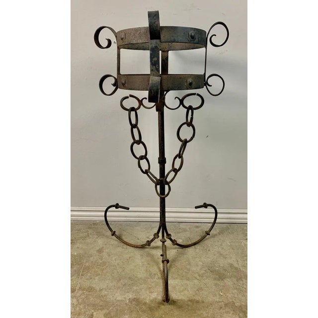 A striking pair of 19th-century wrought iron wall-mounted holders, featuring beautifully hand-forged scrollwork,...
