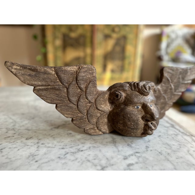 This finely carved wooden cherub head, dating back to around 1800, is a remarkable example of German craftsmanship. Unlike...