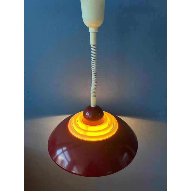 Rare red UFO shaped pendant lamp by Knud Chistensen. The lamp has a metal outer shade and a white, acrylic inner shade....