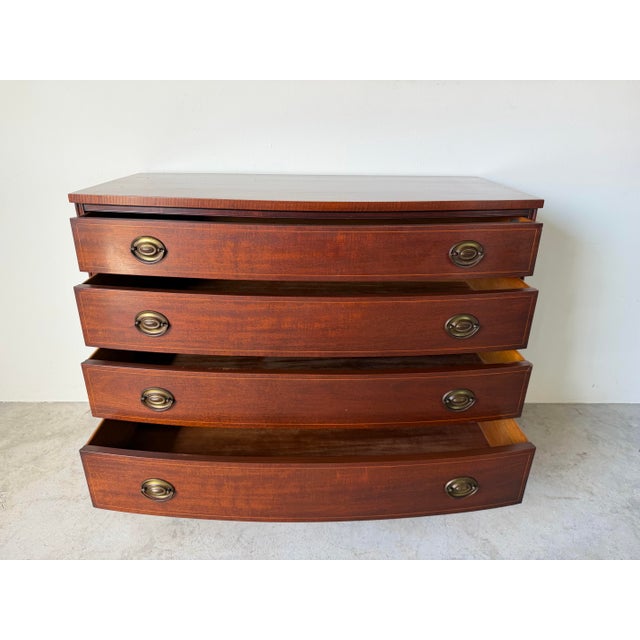 A timeless 1970s Drexel Georgian-style chest of drawers crafted from genuine mahogany with a gracefully serpentine front....