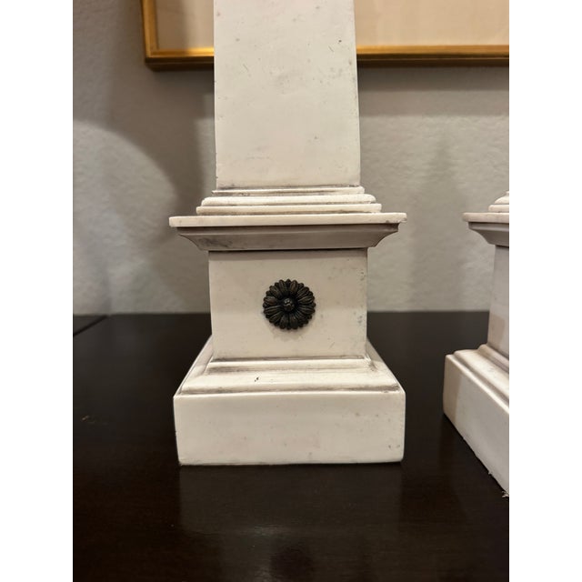 A beautifully sculptural pair of neoclassical faux ivoire obelisks, standing 23.5″ tall with a crisp architectural...