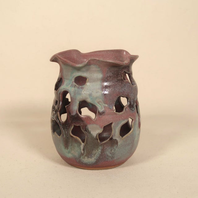 A striking signed studio pottery vessel featuring an organic pierced form with free-flowing cutouts and a softly...