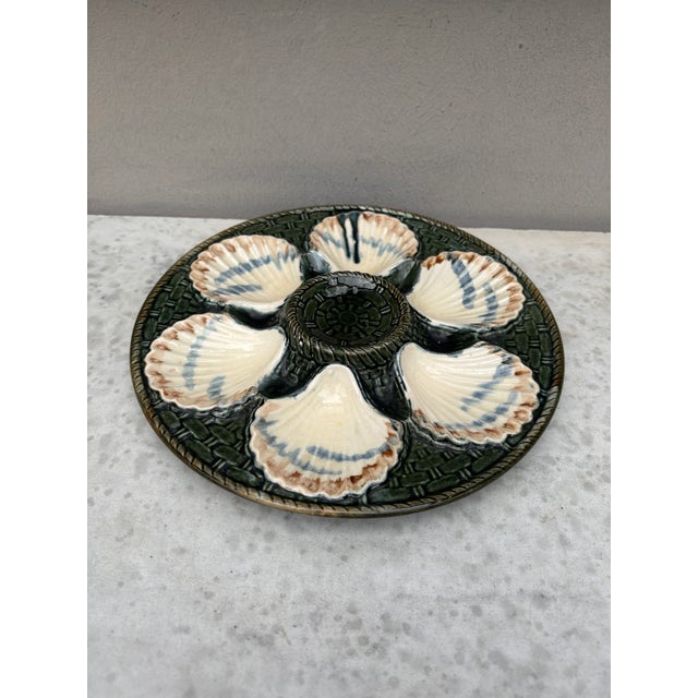 Green Majolica oyster plate, six white wells on a green basket weave, circa 1890 signed Longchamp.