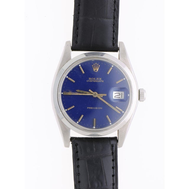 This vintage Rolex Oysterdate Precision reference 6694 features a striking blue dial with applied gold-tone baton indices,...