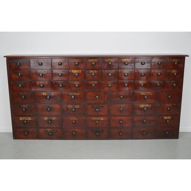 This apothecary bank of drawers was designed and made in England, late 19th century. It is made from solid wood with hand-...