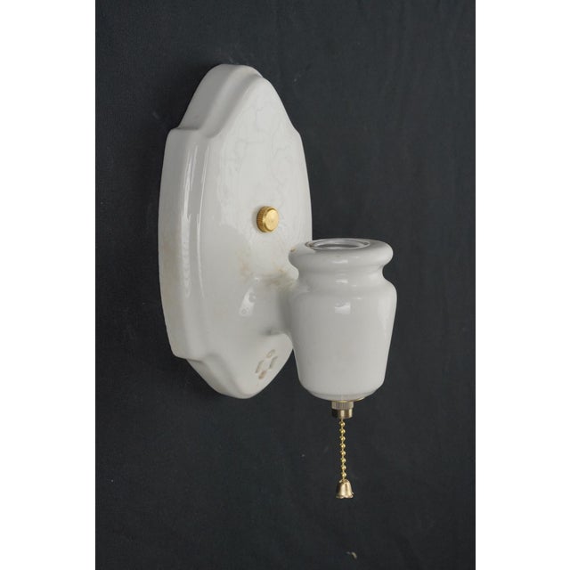 Traditional style white porcelain wall sconce with a pull chain. This sconce requires one Edison style medium base bulb....